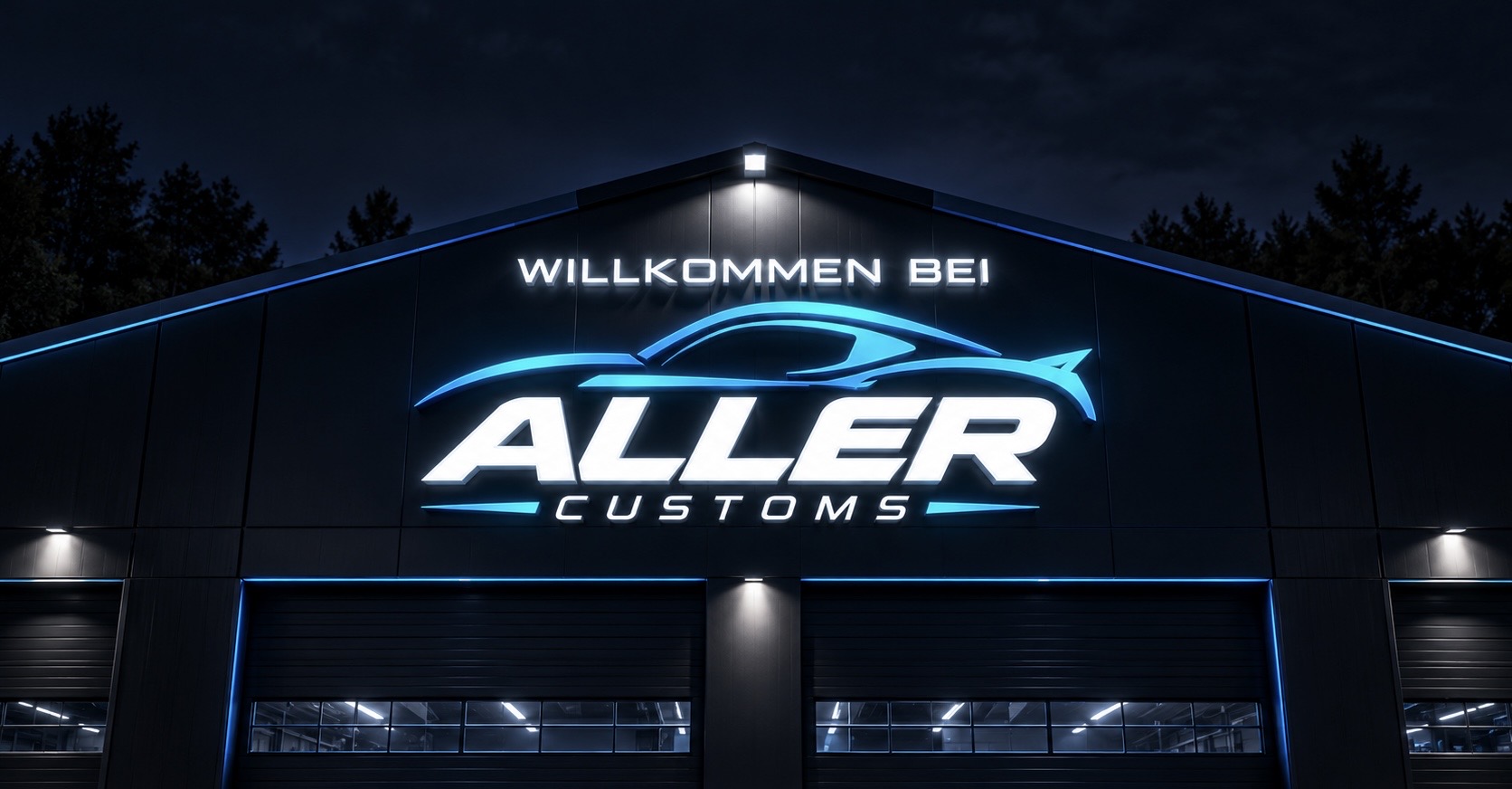 Beleuchtete Front der Aller Customs Werkstatthalle bei Nacht
